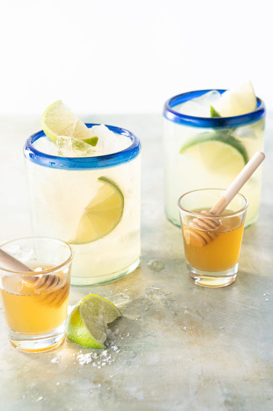 Two honey margaritas with limes and honey.